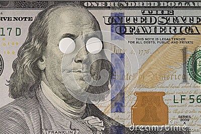 Medical pills on the eyes of Benjamin Franklin on bill of one hundred dollars close-up. insurance medicine, high cost of drugs Stock Photo