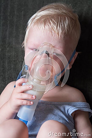 Medical procedures. Inhaler. The Caucasian blonde inhales couples containing medication to stop coughing. The concept of home trea Stock Photo