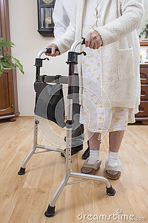 Medical rehabilitation balconies. Grandma learns to walk with the help of a walker and assisted by a nurse. Stock Photo