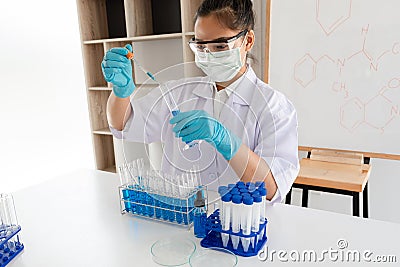 Medical scientists released a sample pipette into a test tube to analyze the virus in a chemical laboratory. Scientific research Editorial Stock Photo