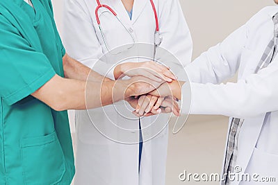 Doctor, surgeon and nurse join hands together. Stock Photo