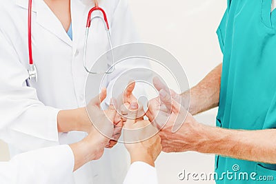 Doctor, surgeon and nurse join hands together. Stock Photo