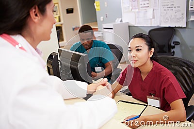 Medical Staff Meeting At Nurses Station Stock Photo