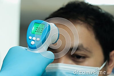 Medical staff use infrared forehead thermometer for check body temperature, Covid-19 outbreak concept Stock Photo