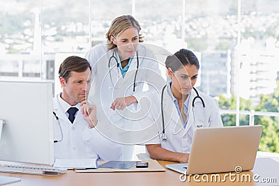 Medical staff working together on a laptop and a computer Stock Photo