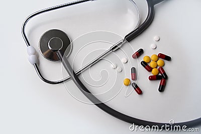 Medical stethoscope and colored drugs, white pills, capsules on a white background, medical concept, top view, close-up, copy Stock Photo