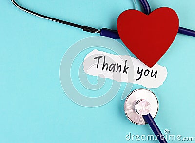 Medical stethoscope, red healthy heart and thank you doctor text on blue background Stock Photo