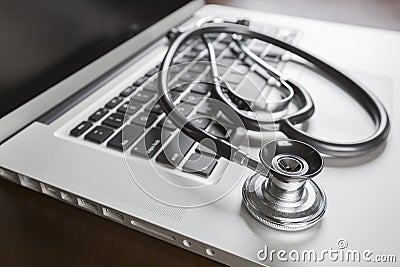 Medical Stethoscope Resting on Laptop Computer Stock Photo