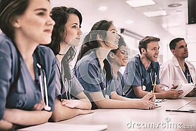 Medical students listening sitting at desk Stock Photo