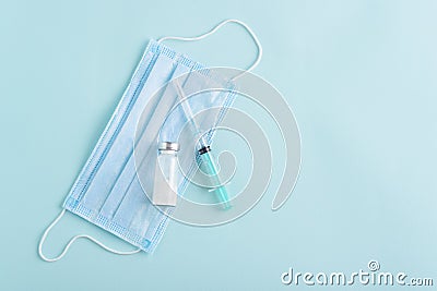 Medical syringe, ampoule, medical mask on blue background, vaccination, inoculation concept, copy space Stock Photo