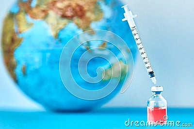 Medical syringe and ampoule with a medicine against Earth globe. ï¿½oncept of epidemic, virus and human infection Stock Photo