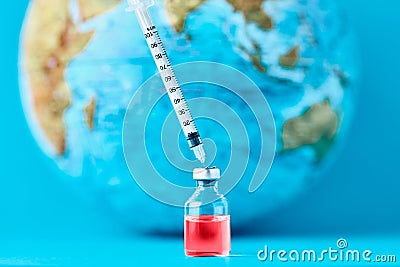 Medical syringe and ampoule with a medicine against Earth globe. ï¿½oncept of epidemic, virus and human infection Stock Photo