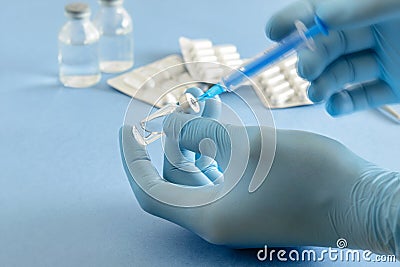 Medical syringe in doctorÂ´s hands on the medical table background. Hands of doctor in medical gloves Stock Photo