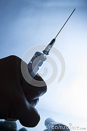 Medical syringe on gradient background with hand Stock Photo