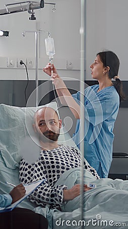 Medical team monitoring patient vital checking heart rate injecting fluids Stock Photo