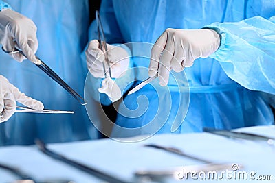 Medical team performing operation. Group of surgeon is working in operating theatre toned in blue Stock Photo