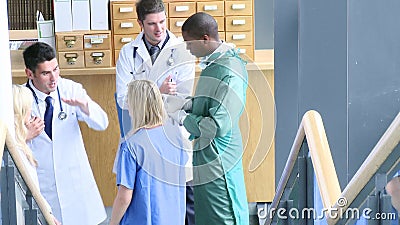 Medical team speaking in the hall of a hospital footage. High view of medical team speaking in the hall of a hospital footage in high definition stock video footage Medical team speaking in the hall of a hospital footage. High view of medical team speaking in the hall of a hospital footage in high definition stock video footage