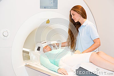 Medical technical assistant preparing scan of patient's head with MRI Stock Photo