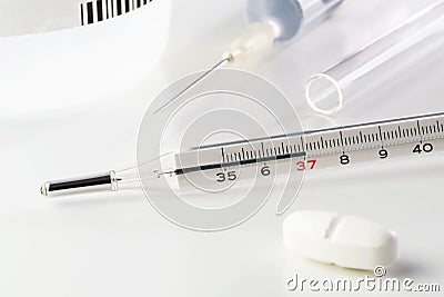 Medical thermometer, pill, vaccine in medical syringe and glass tube on white Stock Photo