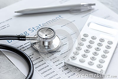 Medical treatmant billing statement with stethoscope and calculator on stone background Stock Photo