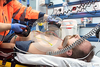 Medical urgency in the ambulance. Emergency doctor using defibrillator Stock Photo