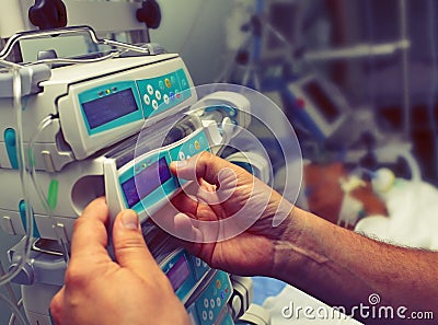 Medical worker configures equipment in ICU Stock Photo