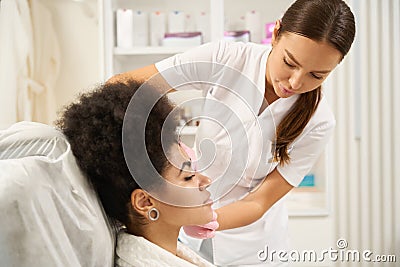 Medical worker doing facial plasmolifting for American American lady Stock Photo