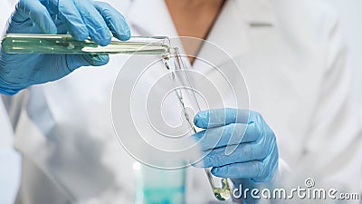 Medical worker pouring yellow liquid into test tube, perfume production Stock Photo