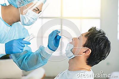 Medical worker taking swab for corona virus sample from potentially infected man Stock Photo