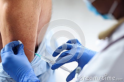 Medical worker vaccinating an elderly man at the clinic Stock Photo