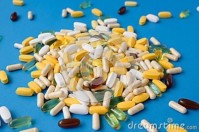 medicament concept of many pills tablets softgels and capsules on blue surface Stock Photo