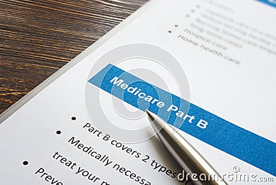 Medicare part B cover list and metal pen. Stock Photo