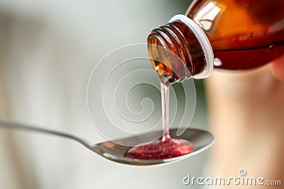 Medication or antipyretic syrup and spoon Stock Photo