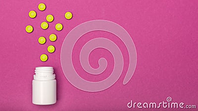 Medication bottle and yellow pills spilled on bright pink coloured background. Medication and prescription pills flat lay. Stock Photo