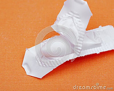 Medication in disposable plastic suppository moulds on orange. Rectal drug administration Stock Photo