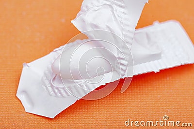 Medication in disposable plastic suppository moulds on orange. Rectal drug administration Stock Photo