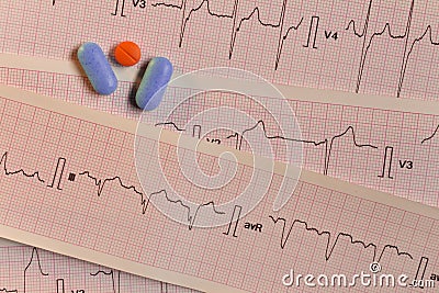 Medications in the form of tablets for oral use on an electrocardiogram background. Stock Photo