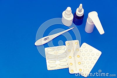 Medications, pills and a thermometer on a bright background Stock Photo