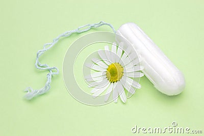 Medicinal chamomile flower and menstrual sanitary tampon. Woman critical days, gynecological menstruation cycle. Menstruation sani Stock Photo