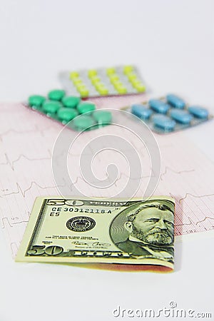 Medicinal pills, dollars on the background of the cardiogram Stock Photo