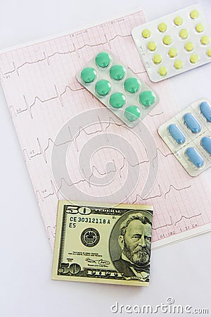 Medicinal pills, dollars on the background of the cardiogram Stock Photo