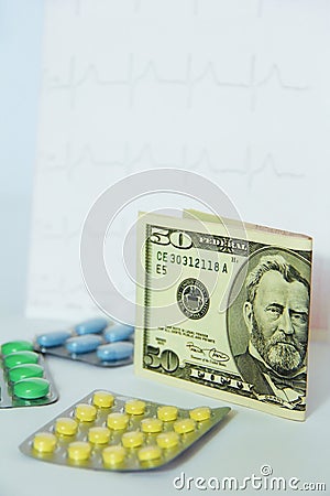 Medicinal pills, dollars on the background of the cardiogram Stock Photo