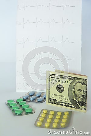 Medicinal pills, dollars on the background of the cardiogram Stock Photo