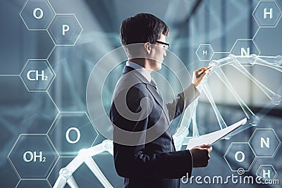 Medicine, bioengineering and technology concept with serious man in black suit using stylus working with digital touch screen with Stock Photo