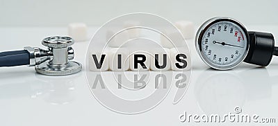 On a reflective white surface lies a stethoscope and cubes with the inscription - VIRUS Stock Photo