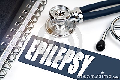 On the table are a stethoscope and a notebook, next to the inscription - EPILEPSY Stock Photo