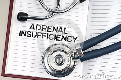 On the table is a stethoscope, a pen and a notebook in which it is written - Adrenal Insufficiency Stock Photo