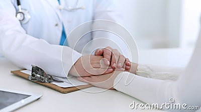 Medicine doctor hand reassuring her female patient closeup. Medicine, comforting and trusting concept in health care Stock Photo