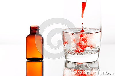 Medicine dropping into a glass of water Stock Photo