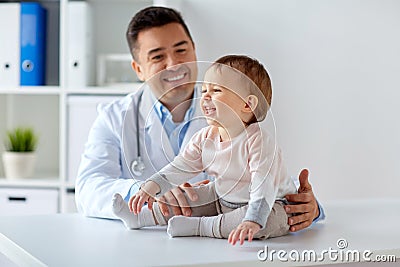 Happy doctor or pediatrician with baby at clinic Stock Photo